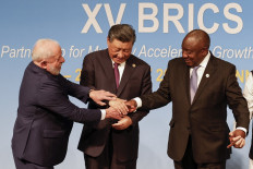 (From left to right) President of Brazil Luiz Inacio Lula da Silva, President of China Xi Jinping and South African President Cyril Ramaphosa gesture during the 2023 BRICS Summit at the Sandton Convention Centre in Johannesburg on August 23, 2023. 
