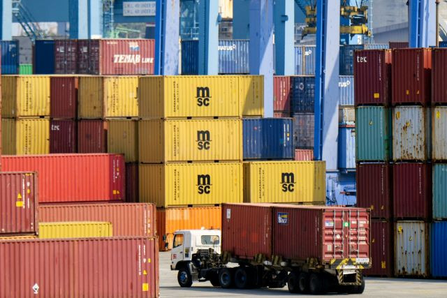 A freight truck drives past stacks of containers on Aug. 18, 2023, at Tanjung Priok Port in North Jakarta.