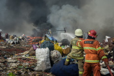 Firefighters try on Aug. 24, 2023, to extinguish a fire that has been burning for five days and polluting the air for 12,000 residents in the area, at a landfill in Sarimukti on the outskirts of Bandung, West Java.