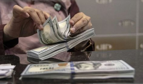 A teller counts United States dollar banknotes on Oct. 4, 2022 at a money changer in Jakarta.