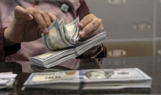 A teller counts United States banknotes on Oct. 4, 2022, at a money changer in Jakarta.