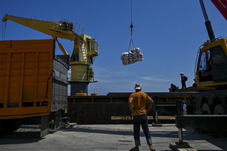Workers unload sacks of rice imported from Thailand on June 22, 2023, from a cargo ship at Malahayati Port in Krueng Raya, Aceh.