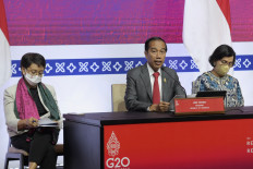 President Joko "Jokowi" Widodo (center) speaks on Nov. 16, 2022, accompanied by  Foreign Minister Retno LP Marsudi (left) and Finance Minister Sri Mulyani Indrawati (right), at the Bali International Convention Centre (BICC), during the G20 Summit in Bali. At the summit, Indonesia received a commitment from the Just Energy Transition Partnership (JETP) of US$20 billion.