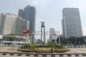 A Jakarta park agency worker walks on Sept. 4, 2023, near the logo of Indonesia’s ASEAN chairmanship at the Hotel Indonesia traffic circle in Central Jakarta. 
