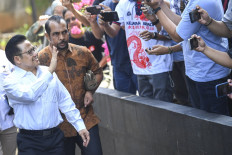 National Awakening Party chair Muhaimin Iskandar (left) waves to the press on Sept. 7, 2023, upon arriving at the Corruption Eradication Commission (KPK) headquarters in Jakarta. Muhaimin promised on Dec. 18, 2023, to eradicate online loans and gambling if elected vice president with presidential candidate Anies Baswedan. 