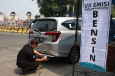 Increased enforcement: A Jakarta Environment Agency official tests a car’s emissions at the Blok M bus terminal on Aug. 25, 2023, the same day the city administration began a trial emissions testing period in an effort to curb air pollution.

