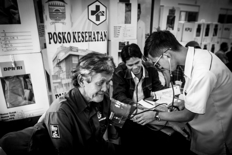 A polling station working committee (KPPS) member (left) takes a blood pressure test on April 24, 2019, during the vote recapitulation process at a meeting hall in Ilir Timur I district in Palembang, South Sumatra. Blood pressures test services were provided for polling station officials to ensure good health during the vote recapitulation process. According to data compiled by the Health Ministry from local health agencies, the number of polling station officials who died reached 527 people while 11,239 others acquired fatigue-related illnesses.