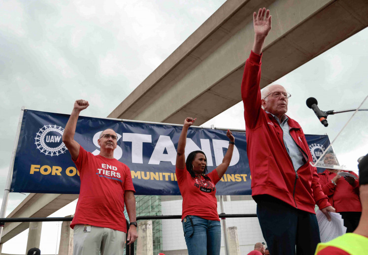 US Senator Bernie Sanders gestures as he speaks to the crowd as United Auto Workers president Shawn Fain and UAW Region 1 Director LaShawn English listen during a rally in support of striking UAW members in Detroit, Michigan, US  September 15, 2023. 