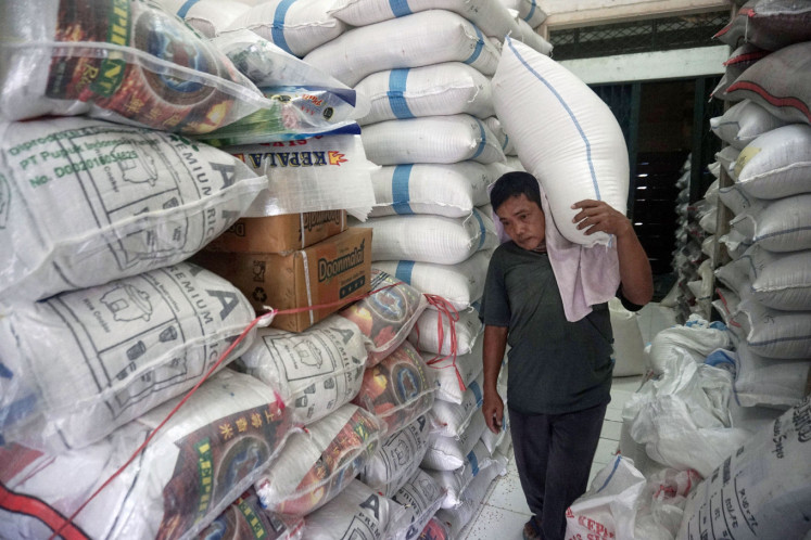 A worker carries a bag of rice at the Cipinang Central Rice Market in East Jakarta on March 15, 2021.