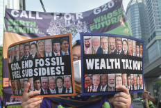 A protester shows posters and signs during a protest at the Indian Embassy in Jakarta on Sept. 8, 2023. The protesters demanded countries of the Group of 20 to focus on renewable energy development for developing countries during the G20 Summit in New Delhi.