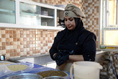 Abir Jassem prepares food inside the kitchen of the women-run catering service “Taste of Mosul“, in Iraq's northern city of Mosul, on September 13, 2023.