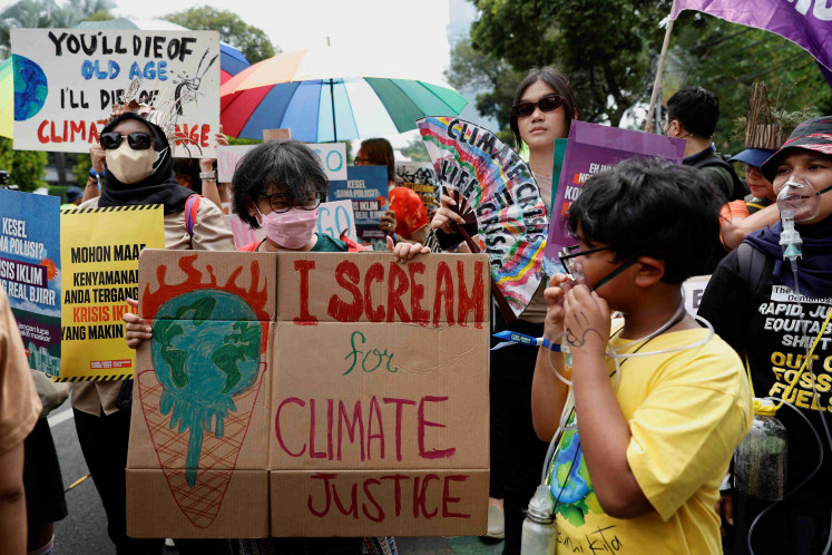 Activists carry placards during a Global Climate Strike rally in Jakarta, September 17, 2023.
