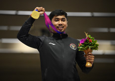 Indonesian shooting athlete Muhammad Sejahtera Dwi Putra celebrates on the podium after winning gold in the men's 10m running target at the 2022 Asian Games in the Fuyang Yinhu Sports Center, Hangzhou, China September 25, 2023.
