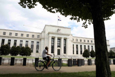 A cyclist passes the Federal Reserve building in Washington, DC, US, August 22, 2018.