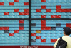 A man looks at an electronic quotation board displaying stock prices of each company listed on the Tokyo Stock Exchange along a street in Tokyo on Sept. 28, 2023. 