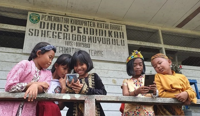 Students use mobile devices on Aug. 15, 2023 to access the free internet service at SDN 008 elementary school in Muyub Ulu village, West Kutai regency, East Kalimantan.