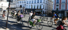Cyclists peddle along streets in Paris. 