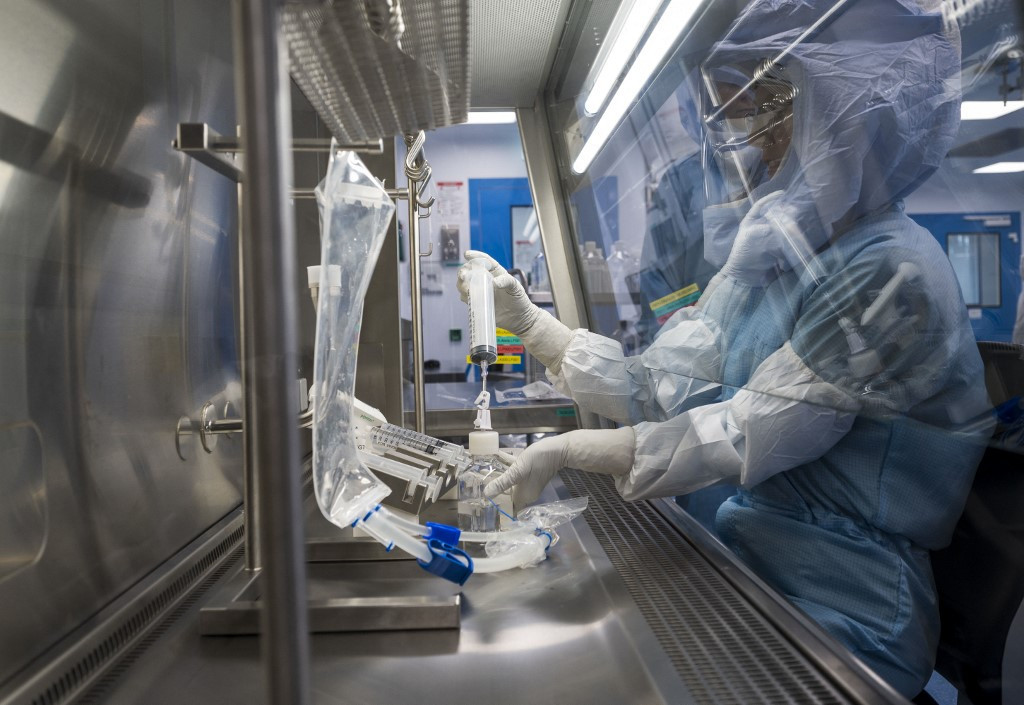 Employees in cleanroom suits test the procedures for the manufacturing of the messenger RNA (mRNA) COVID-19 vaccine on March 27, 2021, at a new manufacturing site of German company BioNTech in Marburg, central Germany.