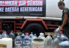 A resident places water jugs in line to get clean water from a water supply truck on Oct. 10, 2023, in Semplak village, Bogor, West Java.
