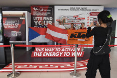 A MotoGP fan takes a photo in front of the Pertamina Grand Prix of Indonesia 2023 booth at Lombok International Airport in Central Lombok on Thursday. 