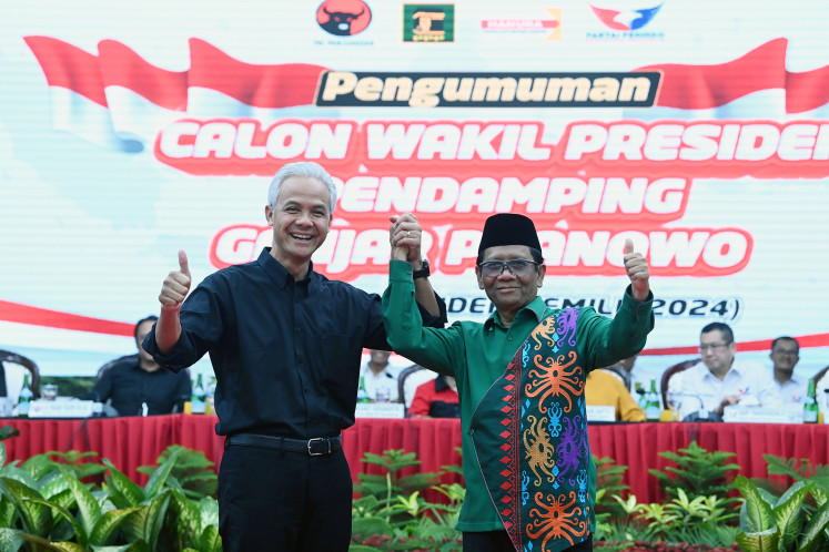 Presumptive presidential nominee from the Indonesian Democratic Party of Struggle (PDI-P) Ganjar Pranowo (left) and running mate Mahfud MD hold hands on Oct. 18, 2023, after the party announced that Mahfud would be its vice-presidential candidate, at the PDI-P headquarters in Jakarta.
