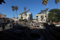 People inspect the remnants of the Al-Ahli Hospital in Gaza City on Oct. 18, 2023, where hundreds of Palestinians were killed in a blast that Israeli and Palestinian officials have blamed on each other, and where Palestinians who fled their homes were sheltering amid the ongoing conflict with Israel.