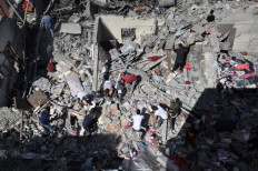 People search for victims among destroyed buildings following an Israeli air strike on Rafah, in the southern Gaza Strip, on Oct. 17, 2023. Asian markets tumbled Thursday, with some warning that a full-blown war was increasingly likely.