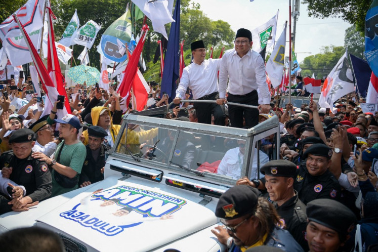 Presidential and vice presidential candidates Anies Baswedan (center left) and Muhaimin Iskandar (center right) greet supporters gathered in front of the General Elections Commission (KPU) headquarters in Jakarta on Oct. 19, 2023, to support their registration as candidates for the Feb. 14, 2024, presidential election.