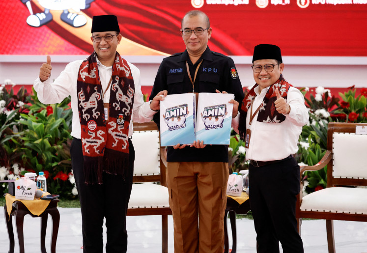 Presidential candidate Anies Baswedan and his running mate Muhaimin Iskandar take a group photo with General Elections Commission (KPU) head Hasyim Asyari at the KPU’s headquarters in Jakarta on Oct. 19, 2023, as they hold their candidacy registration documents.