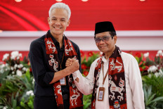 Ganjar Pranowo (left), presidential candidate of the ruling Indonesian Democratic Party-Struggle (PDI-P), and his running mate, Mohammad Mahfud Mahmodin, Indonesian chief security minister, known as Mahfud MD, pose for photographs after registering themselves, at the election commission headquarters in Jakarta, October 19, 2023. 
