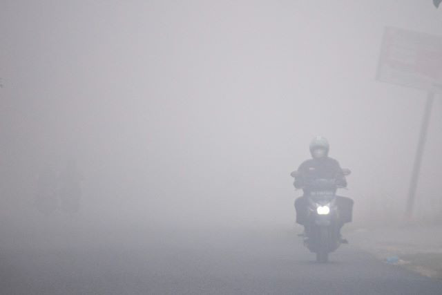 Murky ride: A motorcyclist braves thick smog from forest fires on Oct. 7, 2023 as he rides along Jl. Pendidikan in Jakabaring, a district in South Sumatra’s provincial capital Palembang.

