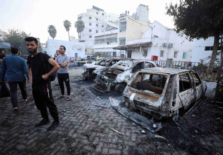 People inspect the area of Al-Ahli hospital where hundreds of Palestinians were killed in a blast that Israeli and Palestinian officials blamed on each other, and where Palestinians who fled their homes were sheltering amid the ongoing conflict with Israel,  in Gaza City, October 18, 2023.  