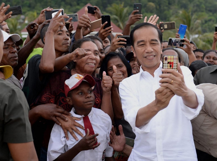 President Joko “Jokowi“ Widodo takes a selfie with residents welcoming him to Wamena, Papua, on Oct. 28, 2019.