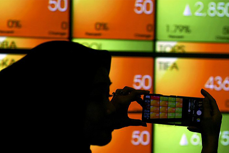 An employee takes a picture of stock movements at the Indonesian Stock Exchange (IDX) in Jakarta on Tuesday, July 4, 2023. With a 1.57 percent IDX Composite decline on Monday, Oct. 24, 2023,  foreign investors sold Rp 592.81 billion (US$37.81 million) worth of stocks.