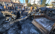 People search through debris on Oct. 18, 2023 at the site of an unidentified blast at al-Ahli Arab Hospital in Gaza City.