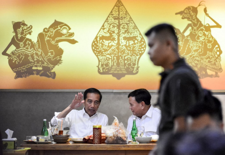 President Joko 'Jokowi' Widodo (left) chats with former general Prabowo Subianto (centre right) at a public restaurant in Jakarta on July 13, 2019, during their first meeting since the April 17 general election. 