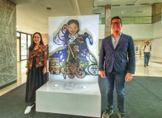Indonesian artist Cathrine Oslo (left) and Konnect ASEAN project director Benjamin Hampe pose in front of "Seizing Identity" after an interview.