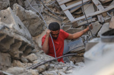 Search and rescue: A Palestinian man looks for survivors on Oct. 31, 2023, in the rubble of a building following Israeli bombing in Rafah in the southern Gaza Strip.
