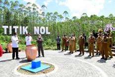 This handout photo taken and released on March 14, 2022 from the Presidential Palace shows Indonesia's President Joko Widodo (C-white shirt) mixing water and samples of soil from 34 provinces during a ceremony in Penajam Paser Utara, East Kalimantan on March 14, 2022, as the government prepares to move its capital from Jakarta to East Kalimantan.

