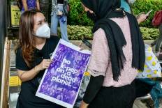 Activists with placards appeal to the public to vote for candidates who care about climate change in the 2024 general election during a rally in Jakarta on March 3, 2023.