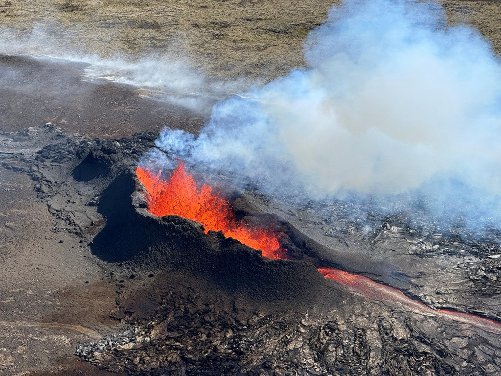 Lava spurts and flows after the eruption of a volcano in the Reykjanes Peninsula, Iceland, on July 12, 2023, as seen in this handout picture taken from a Coast Guard helicopter.