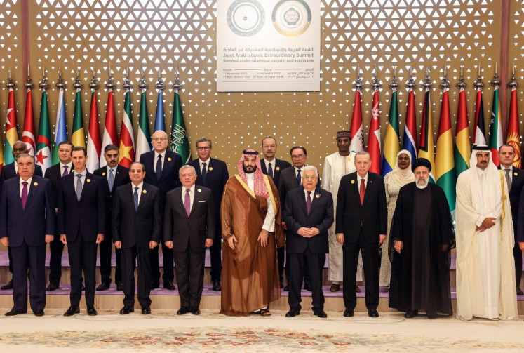 This handout picture provided by the Palestinian Press Office (PPO) on November 11, 2023, shows front row from 2nd left: Syria's President Bashar al-Assad, Egypt's President Abdel Fatah al-Sisi, Jordan's King Abdullah II, Saudi Crown Prince Mohammed bin Salman, Palestinain president Mahmud Abbas, Turkish President Recep Tayyip Erdogan, Iran's President Ebrahim Raisi and Qatar's Emir Sheikh Tamim bin Hamad al-Thani, standing for a group picture ahead of an emergency meeting of the Arab League and the Organisation of Islamic Cooperation (OIC), in Riyadh. 