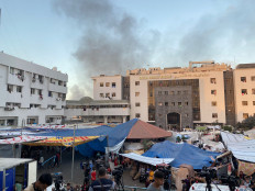 Smoke rises as displaced Palestinians take shelter at Al Shifa hospital, amid the ongoing conflict between Hamas and Israel, in Gaza City, November 8, 2023. 