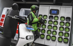 Give and take: A ride-hailing driver exchanges his motorcycle battery for a fully charged one on March 4, 2022, at a Pertamina gas station in East Jakarta.