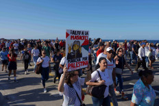 A woman carries a banner which reads in Spanish: “Stop the massacre” during a march in support of Palestinians, calling for a ceasefire and for charging Israel with committing “genocide” in Gaza, in Havana, Cuba, November 23, 2023.
