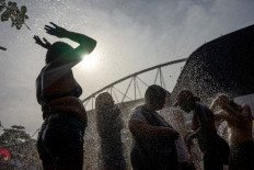 Fans of US singer Taylor Swift cool off as they queue outside the Nilton Santos Olympic Stadium before Swift's concert, “Taylor Swift: The Eras Tour“, amid a heat wave in Rio de Janeiro on November 18, 2023. 