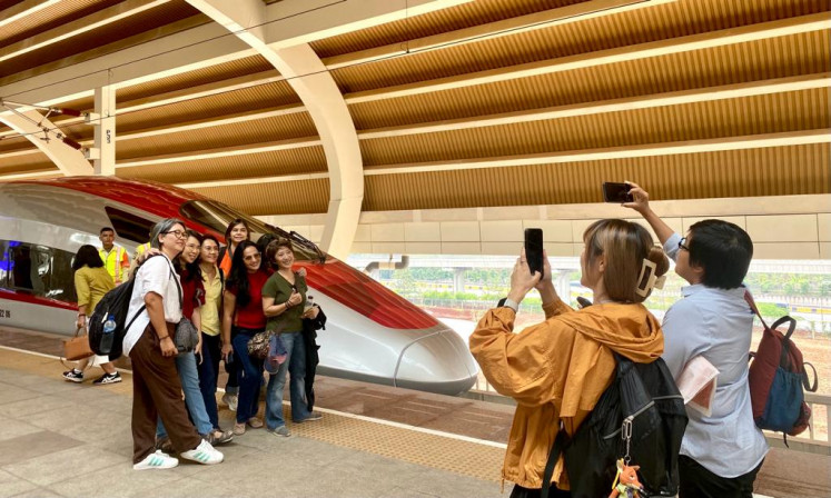 Visitors take pictures with a train of the Jakarta-Bandung high-speed rail (HSR) service branded Whoosh, the first in Southeast Asia, at Halim HSR Station in East Jakarta on Nov. 22, 2023.