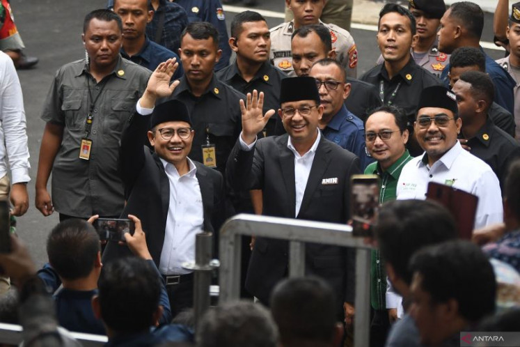 Presidential candidate Anies Baswedan (waving, right) and his running mate Muhaimin Iskandar (waving, left) arrive at the General Elections Commission (KPU) office in Jakarta on Nov. 27, 2023 to take part in a joint declaration to hold a peaceful 2024 election campaign.