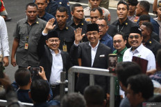 Presidential candidate Anies Baswedan (waving, right) and his running mate Muhaimin Iskandar (waving, left) arrive at the General Elections Commission (KPU) office in Jakarta on Nov. 27, 2023 to take part in a joint declaration to hold a peaceful 2024 election campaign.