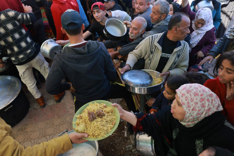 Displaced Palestinians queue for food donations in the southern Gaza Strip city of Rafah, on Nov. 30, 2023. The warring parties have agreed on an extension of the pause in fighting to allow time for Hamas to release more Israeli hostages in exchange for Palestinian prisoners.